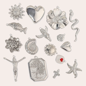 Variety of 14 handmade polished stainless steel pendants featuring floral and cross designs