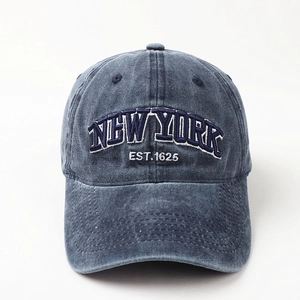 Close-up of NEW YORK white embroidery on washed navy denim cotton baseball cap