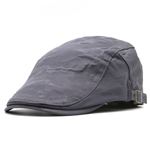 Dettaglio cappello a rete grigio scuro con trama mimetica e fibbia in metallo bronzo