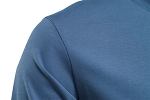 Macro shot of blue cotton t-shirt shoulder seam showing premium stitching and fabric texture