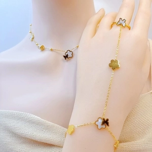 Detail of gold butterfly and flower bracelet ring set with white shell inlay on model