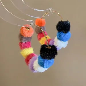 Colorful pom-pom large hoop earrings with golden circles and multi-color plush balls