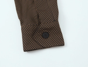 Détail de la manchette de robe à pois avec bouton unique et couture précise