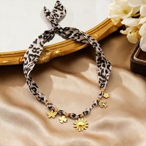 Vintage leopard print ribbon necklace with golden sun and butterfly charms on silk