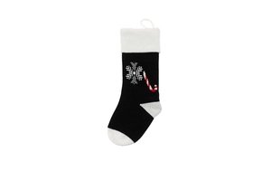 Detail of black knitted Christmas stocking with white snowflakes and candy cane patterns