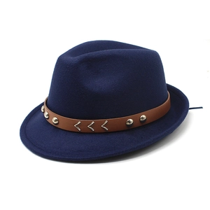 Close-up of navy blue wool fedora hat featuring brown leather band and silver rivet details