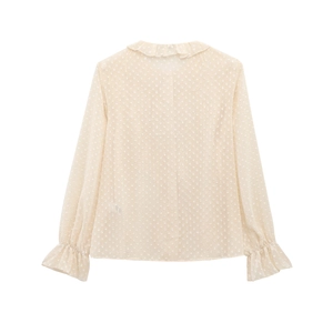 Detailed view of the swiss dot fabric and ruffled collar on this cream chiffon blouse