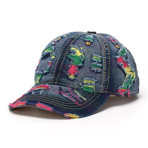 Close-up of distressed denim baseball cap featuring colorful ripped frayed details