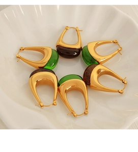 Detail of U-shaped drop earrings with green and amber resin in a vintage style