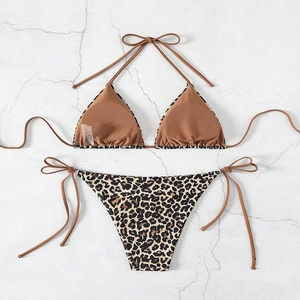 Sexy leopard print halter bikini set with side-tie bottoms on a white stone background