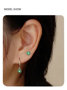Detail of S925 silver flower earrings with emerald green petals on a female model