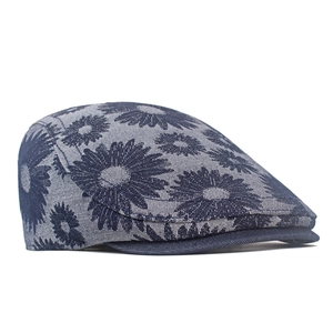 Close-up of denim beret featuring white daisy patterns and detailed fabric texture