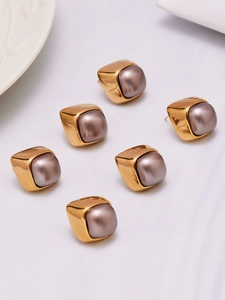 Detail view of 18k gold plated square earrings with grey faux pearls in a group display