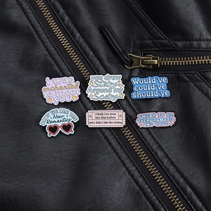 Set of six colorful enamel pins with English lyrics on a black leather jacket