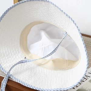 Detail view of the white checkered sun hat featuring a soft inner lining and sweatband