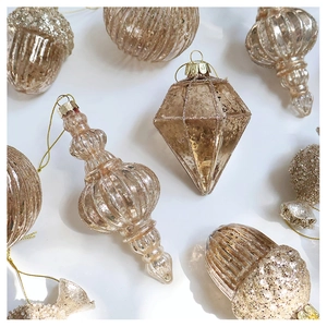 Detail of champagne gold Christmas glass ornaments with acorn and prism shapes
