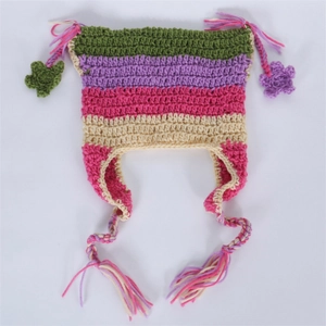 Detail of handmade knit cat ear hat with colorful stripes, tassels, and flower charms
