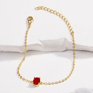 Detail of 14K gold plated bracelet featuring a red oval zircon and lobster clasp closure