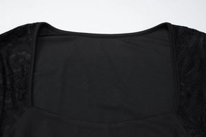 Detail of square neckline and delicate lace patchwork on black long sleeve dress