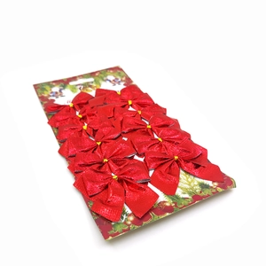 Set of 12 red metallic Christmas tree bows displayed on a decorative packaging card