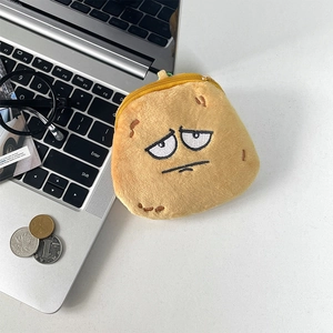 Detailed view of potato plush coin purse with sad face and zipper on a white desk