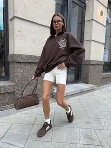 Detailed view of the dark brown half-zip sweatshirt with small front logo graphic print