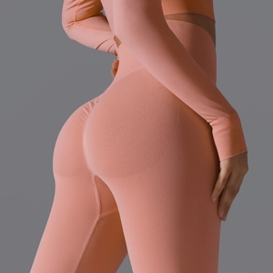 Detail of high-waisted seamless ribbed knit yoga set in peach pink with slim fit texture