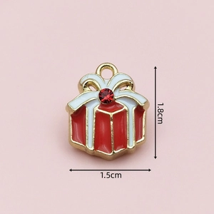 Macro shot of a red and gold enamel Christmas gift box charm with gemstone details