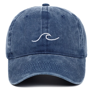 Detailed close-up of white wave embroidery on a vintage navy washed cotton baseball cap