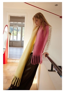 Detail of wool blend gradient scarf with yellow and pink dip-dye finish and fringe edges
