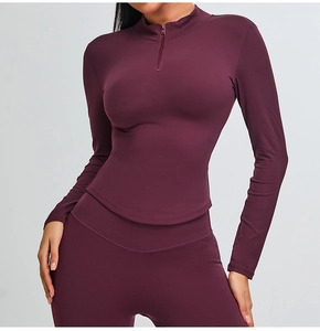 Detail view of burgundy slim fit yoga set with half-zip top and flared sports pants