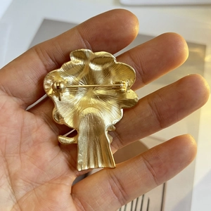 Vue arrière d'une broche florale vintage en or mat montrant le fermoir de l'épingle