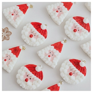 Détail de pendentifs Père Noël en texture crème rouge avec de petits grelots dorés