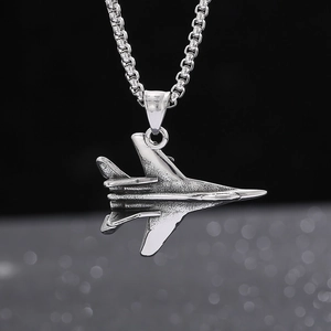 Macro shot of silver fighter jet pendant with metallic chain showing sharp punk details