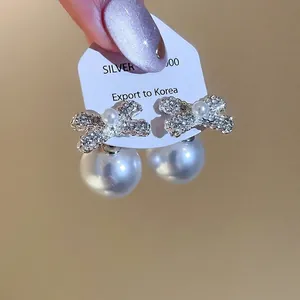 Elegant silver bow earrings with sparkling rhinestones and white pearls for a luxury look