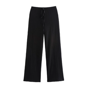 Close-up of black wide-leg trousers featuring pleated texture and adjustable drawstring waist