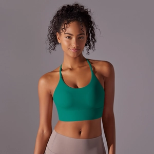 Detail view of emerald green cross-back sports bra with wide supportive hem and soft texture