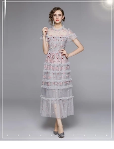 Details eines eleganten Netz-Kleides mit floraler Stickerei und gestuften Rüschen