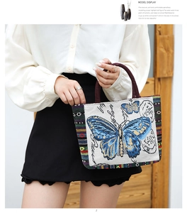 Detail of jacquard tote bag featuring blue butterfly pattern and woven handles
