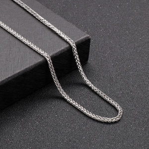 Detailed view of silver stainless steel spiga wheat chain on a black gift box
