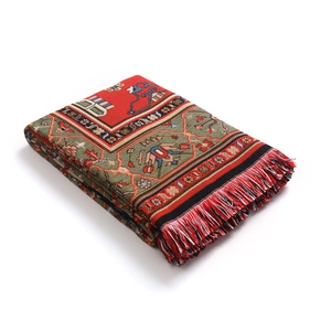 Détail d'une couverture tissée bohème avec motifs géométriques et bordures frangées