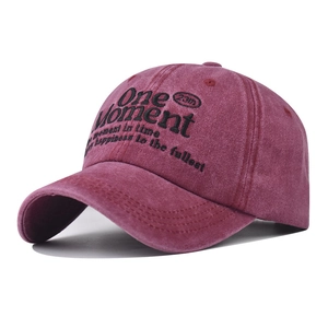 Close-up of One Moment embroidery on vintage washed burgundy cotton baseball cap