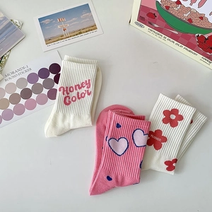 Pink and beige cotton crew socks with heart, flower, and honey letter patterns