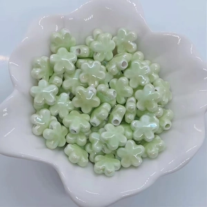 Dettaglio di perline a fiore in ceramica verde chiaro perlato in una ciotola