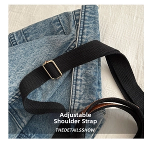 Close-up of black canvas adjustable shoulder strap with durable gold metal buckle