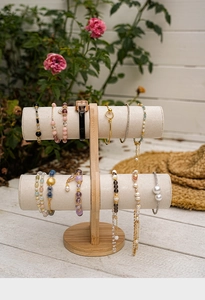 Detailed macro view of 3-tier bamboo jewelry stand with white velvet bars for watches
