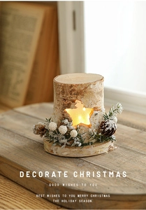 Close-up of wooden star cutout night light with pine cones and berries decoration