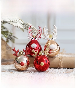 Close-up of reindeer Christmas tree ornaments in red and gold with festive glitter accents