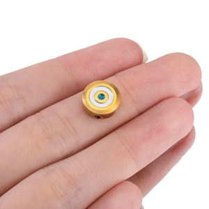Macro shot of a golden stainless steel bead with blue evil eye enamel detail