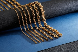 Close-up of golden stainless steel O-chains in various sizes on a dark background